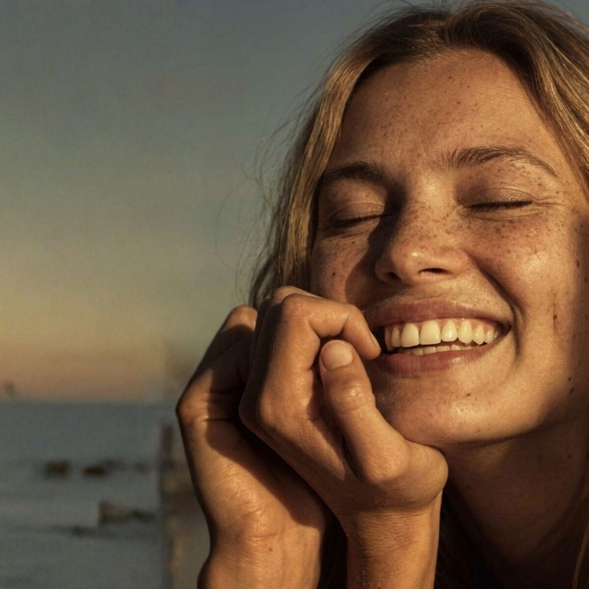 Woman sitting on the beach smiling