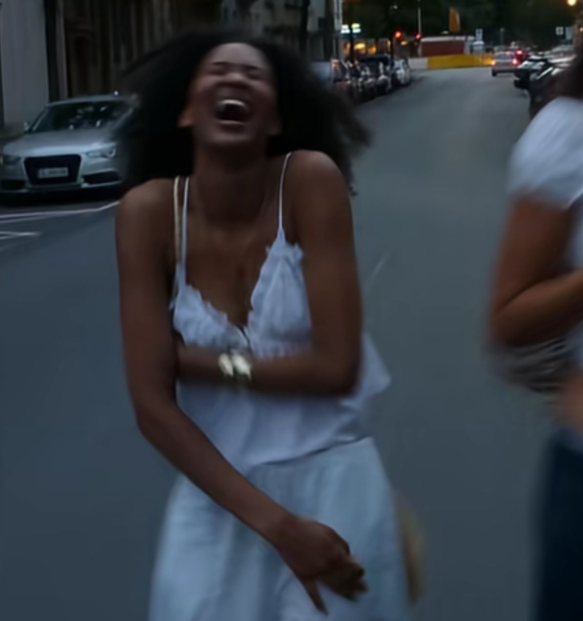 Woman laughing while walking down street