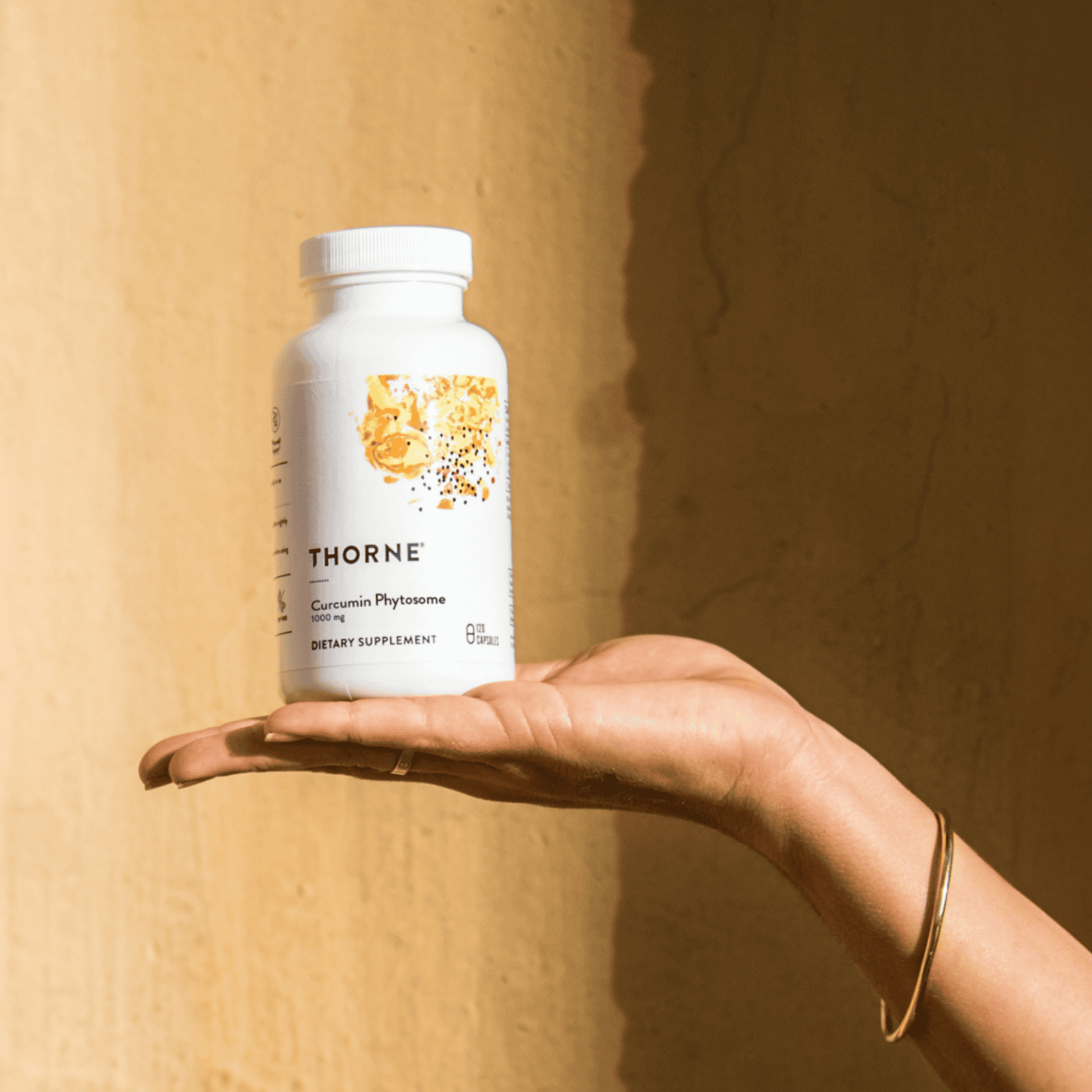 Woman holding bottle of Thorne supplements
