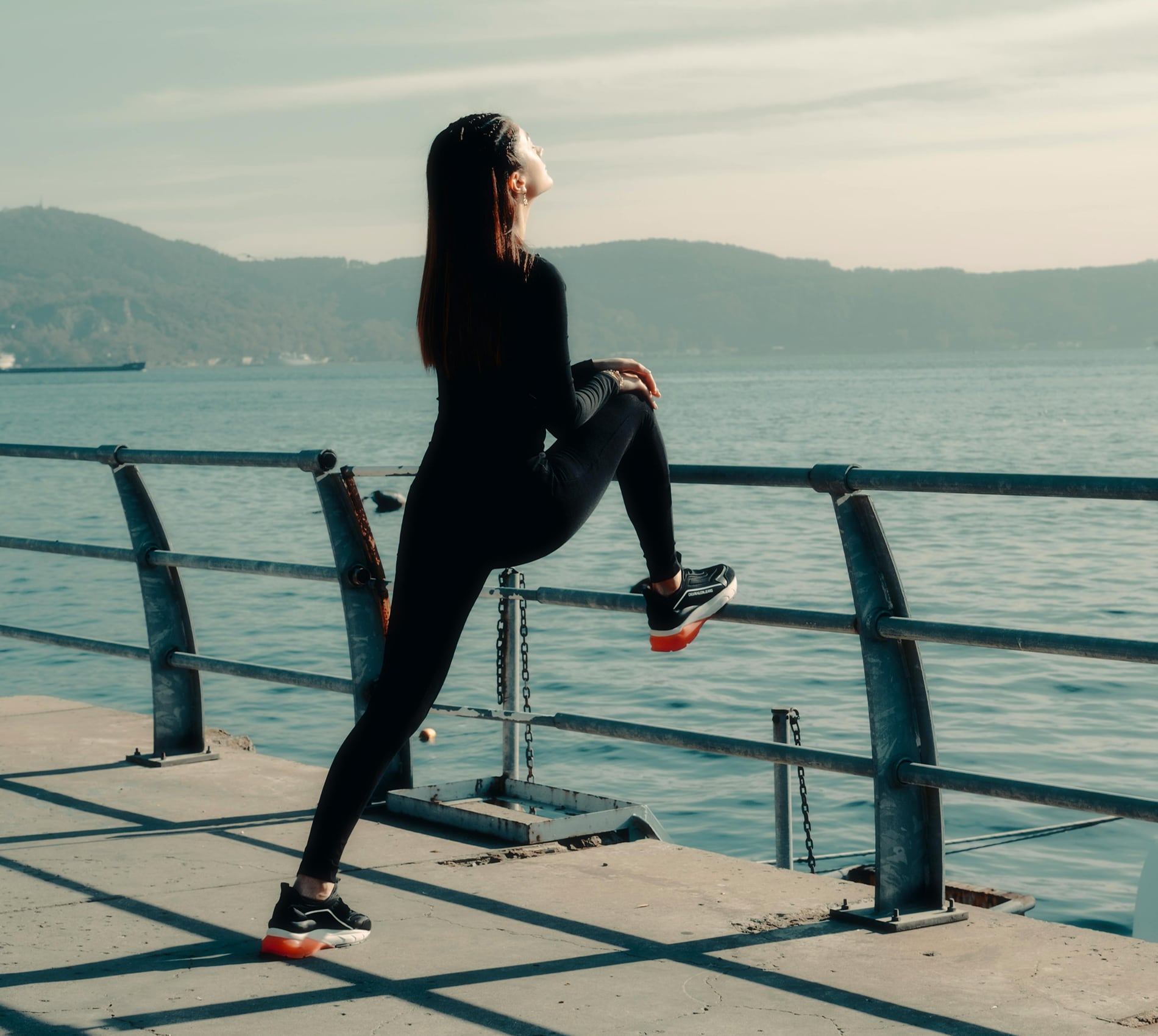 Woman stretching overlooking water
