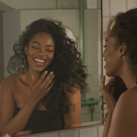 Woman looking in the mirror laughing