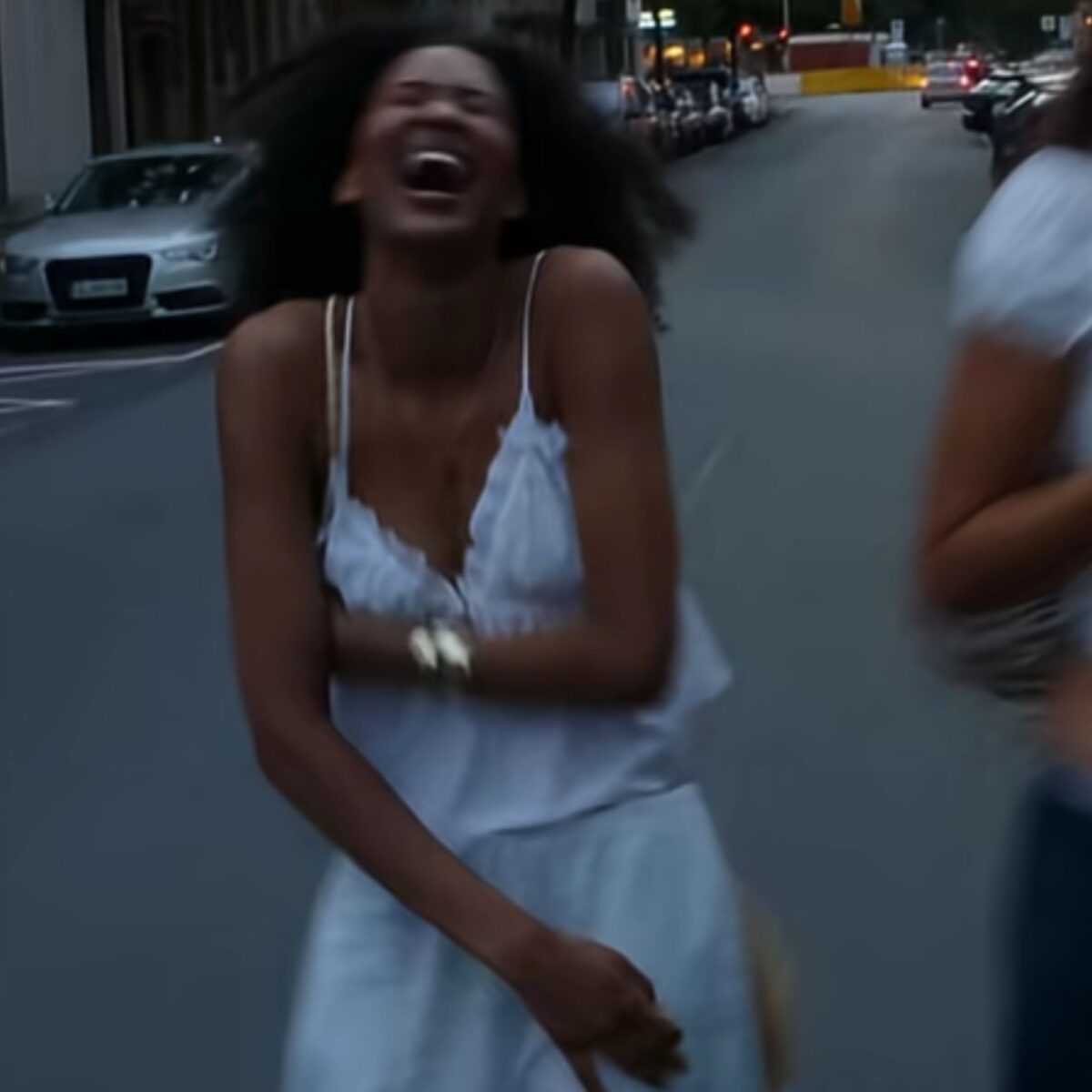 Woman laughing while walking down street